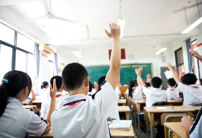 Students in a classroom learning from an ESL teacher teaching English in China