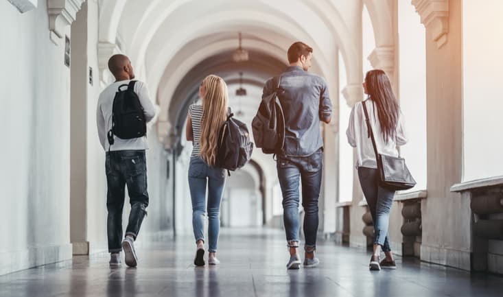 students walking down a university hallway