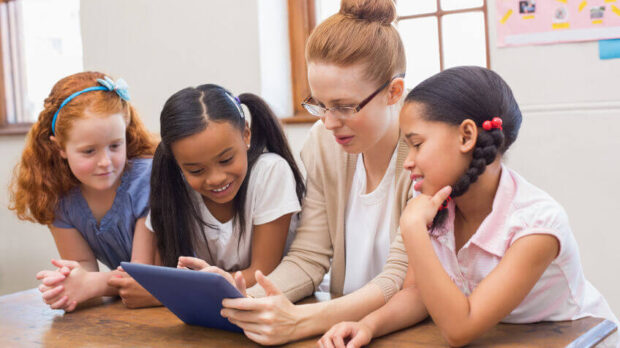 teacher and students gathered around and working through the summer slide