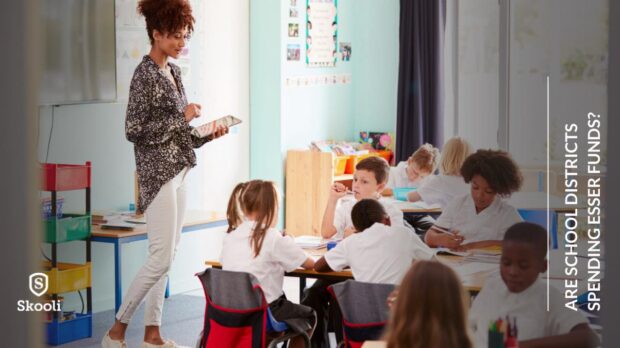 primary school teacher at the front of the class teaching students